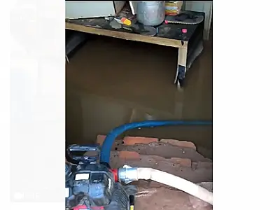 Bombeiros utilizam motobomba para retirar água de casa alagada na rua Campo Grande