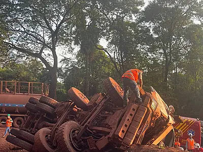 Caminhão de minério capota e condutor fica preso nas ferragens