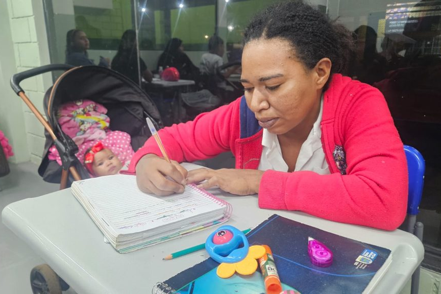 Estudante Beatriz Resende com bebê em sala de aula do EJA Mulher em Campo Grande MS.