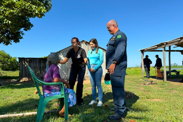 Profissionais da Assistência Social orientam com mulher ribeirinha.